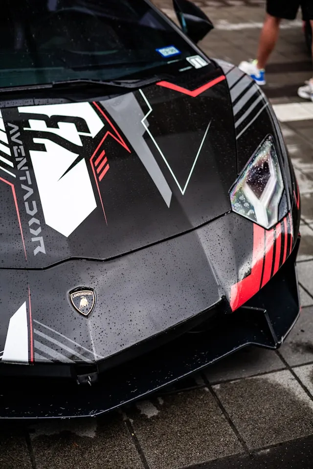 Black supercar hood with large white and red geometric vinyl graphics