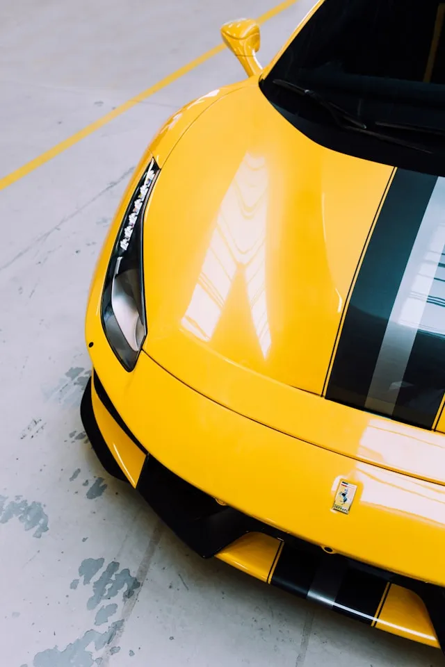 Yellow supercar with black and silver racing stripes over the hood