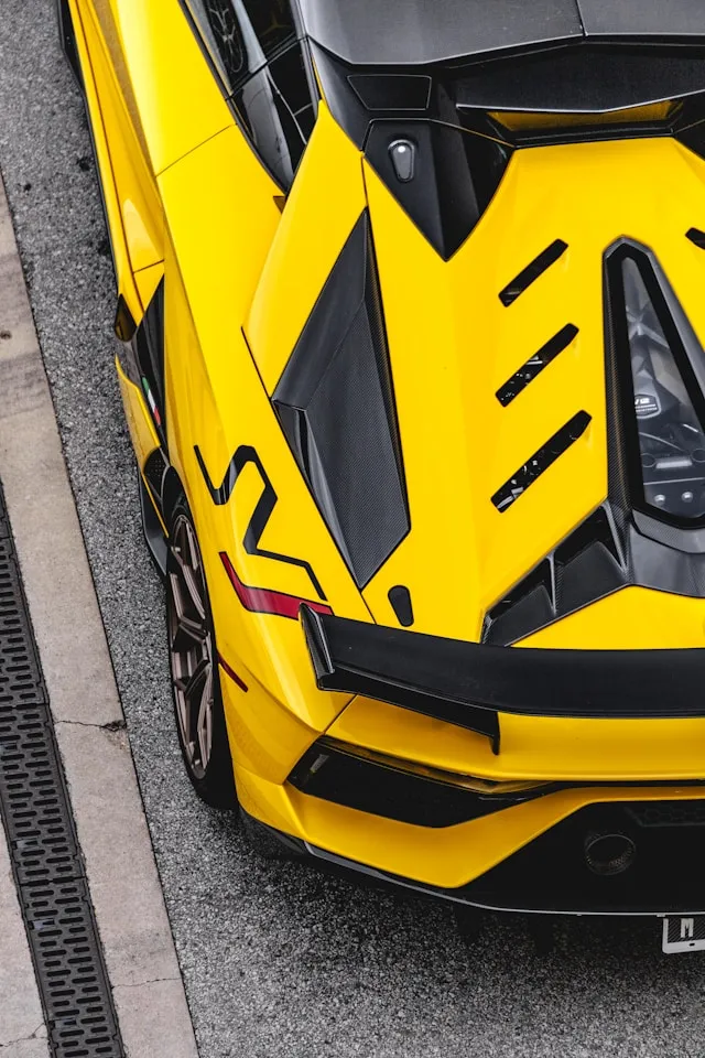 Yellow supercar rear quarter with black stripe and lightning side graphic